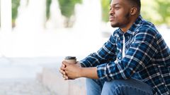 A black man seated thinking