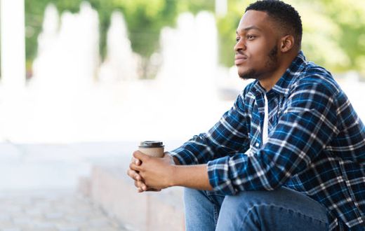 A black man seated thinking