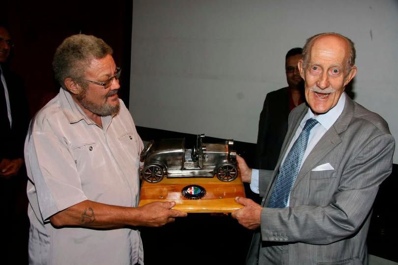 Frank Hetimier (left) hands Alfa Romeo Owners Club chairman Bob Dewar an Alfa Romeo car model during the launch of the 2012 Concours D'elegance at Nairobi Club on March 21, 2012.