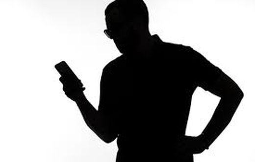 A silhouette of a man  on phone