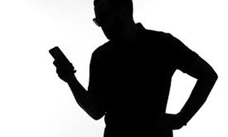 A silhouette of a man  on phone
