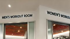 An AI-generated image of an Interior of a modern gym featuring separate workout rooms for men and women The gym is split into two distinct areas