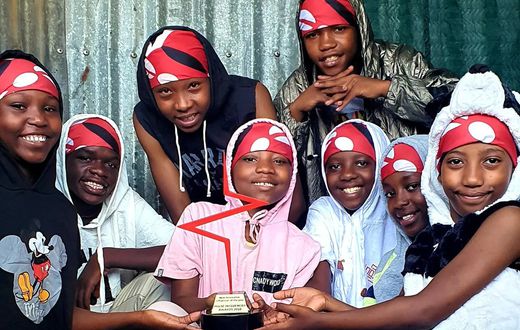 Huruma Town Kids holding their Pulse Influencer Awards plaque
