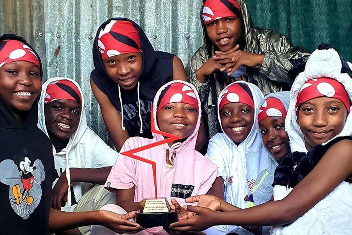 Huruma Town Kids holding their Pulse Influencer Awards plaque