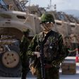 A Kenyan police officer stands next to a row of anti-mine armoured vehicles as the United States Ambassador to the United Nations Linda Thomas-Greenfield toured the Multinational Security Support (MSS) mission in Haiti base near the airport in Port-au-...