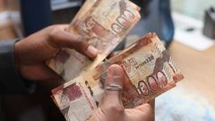 A person holding Kenyan currency