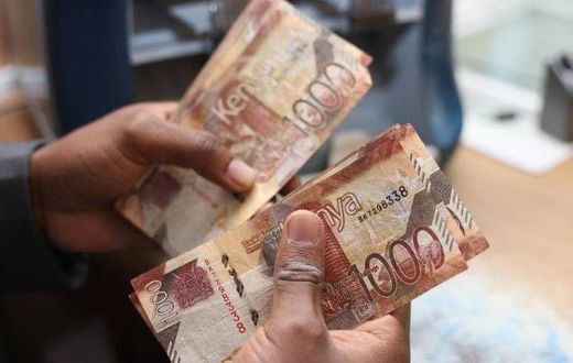 A person holding Kenyan currency