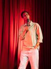 Comedian Adan Abdi on stage at his June 2025 Eid comedy showcase "Go Back To Somalia"
