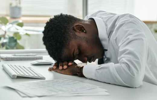 A tired man sleeping on a desk