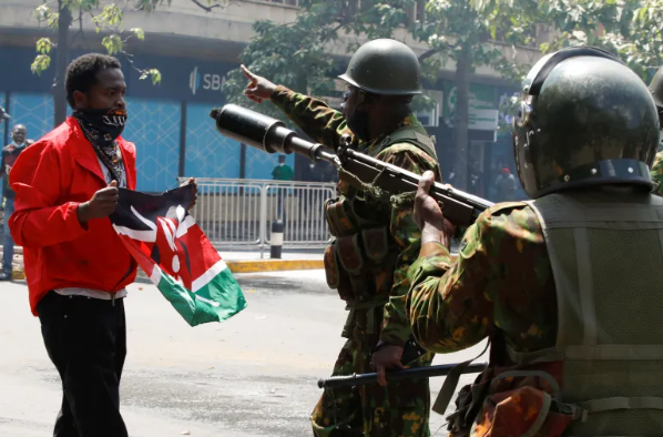 File image of police officers with a peaceful protester in Nairobi