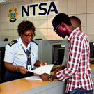 An AI-generated image of an NTSA officer assisting a motor vehicle owner with the ownership transfer process at an NTSA office
