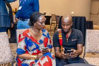 Apexloads Founder and CEO Charles Thuo demonstrates the functioning of the Apexloads mobile application to Uganda's Ambassador to the United States Her Excellency Robie Kakonge on the sidelines of the 19th East Africa Business Network Trade & Investmen...