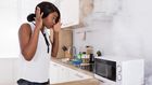 A woman looking at a burnt microwave