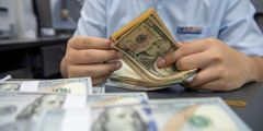 A staff member counts US dollar cash at a bank in Hai 'an, Jiangsu Province, China, Sept 5, 2022.CFOTO/Future Publishing/Getty Images