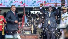 Former President Uhuru Kenyatta, left, looks on as his successor, William Ruto, lifts a sword at his inauguration ceremony on September 13, 2022