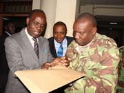 Televangelist Gilbert Deya with a police officer.