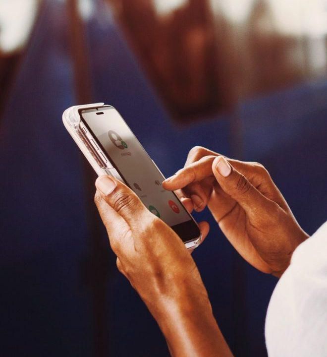 A person dialing a mobile phone