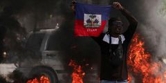 A demonstrator holds up a Haitian flag during protests demanding the resignation of Prime Minister Ariel Henry in Port-au-Prince, Haiti, March 1, 2024 [AP}