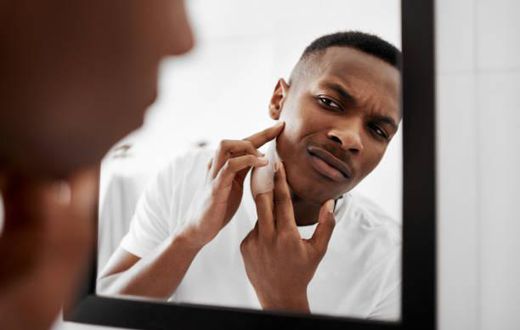 Photo of man looking himself on the mirror