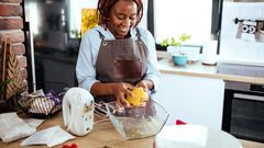 A photo of a woman using a stand mixer in the kitchen