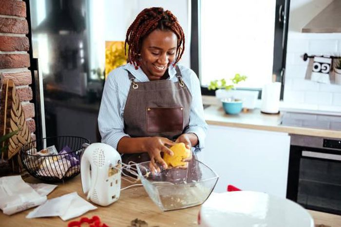 A photo of a woman using a stand mixer in the kitchen