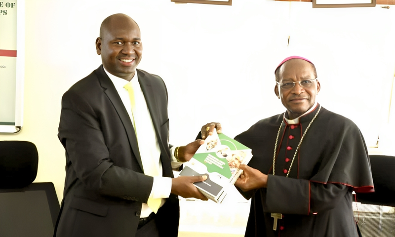 PS Julius Bitok hands over copies of Digital ID FAQ booklet to Kenya Conference of Catholic Bishops chairman Archbishop Martin Kivuva