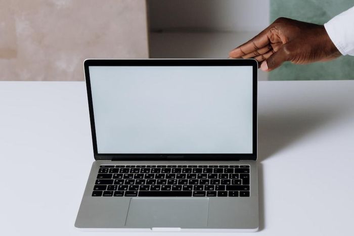 A person using Macbook Pro on white table [Photo: Cottonbro Studio]
