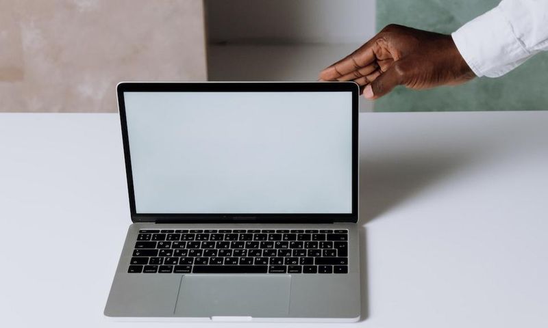 A person using Macbook Pro on white table [Photo: Cottonbro Studio]