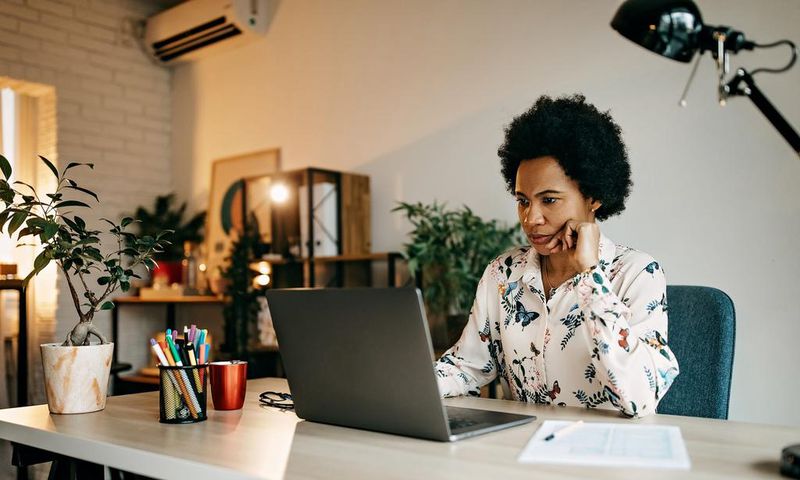 A woman working on laptop at a home office