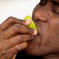 Close-up of a man biting into a lemon half
