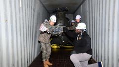 South Korean and US military personnel inspect a 500MD helicopter loaded on a container It is one of six retired helicopters to be donated to Kenya for UN peacekeeping missions