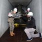 South Korean and US military personnel inspect a 500MD helicopter loaded on a container It is one of six retired helicopters to be donated to Kenya for UN peacekeeping missions