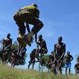 A KDF official takes recruits through a drill during tryouts