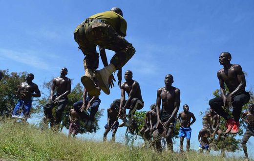 A KDF official takes recruits through a drill during tryouts