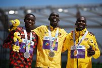 Gold medallist Uganda's Joshua Cheptegei (C), silver medallist Stanley Waithaka Mburu (L) and bronze medallist Uganda's Jacob Kiplimo (R) pose on the podium during the medal ceremony for the men's 10,000m during the World Athletics Championships at Hayward Field in Eugene, Oregon on July 17, 2022.  (Photo by BEN STANSALL/AFP via Getty Images)