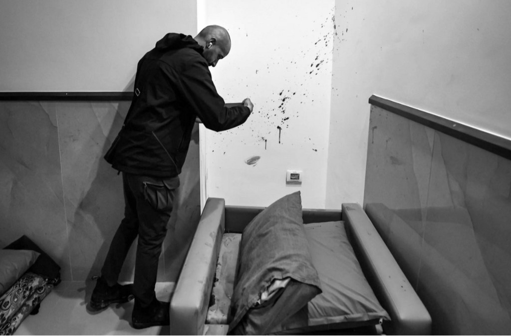 A Palestinian inspects the blood spatter on a wall in another part of the Ibn Sina Hospital after the Israeli raid that the army says targeted Hamas militants © Zain JAAFAR / AFP