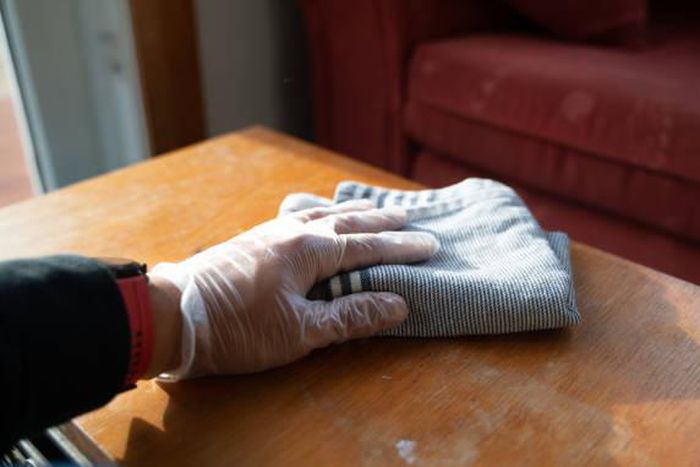 A person wiping dust in a house
