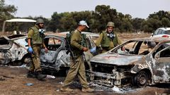 Israel soldiers inspect burnt cars at the site of the Hamas terrorist attacks on the Nova music festival in southern Israel.Amir Cohen/Reuters