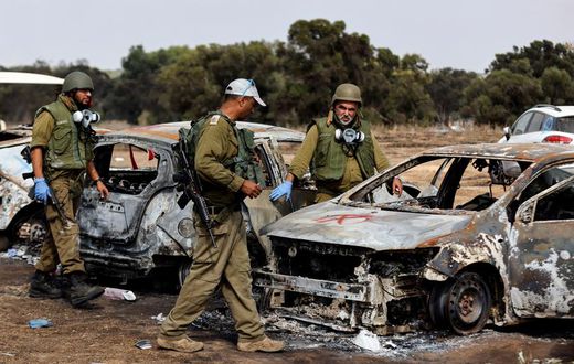 Israel soldiers inspect burnt cars at the site of the Hamas terrorist attacks on the Nova music festival in southern Israel.Amir Cohen/Reuters