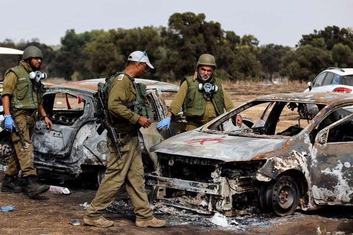 Israel soldiers inspect burnt cars at the site of the Hamas terrorist attacks on the Nova music festival in southern Israel.Amir Cohen/Reuters