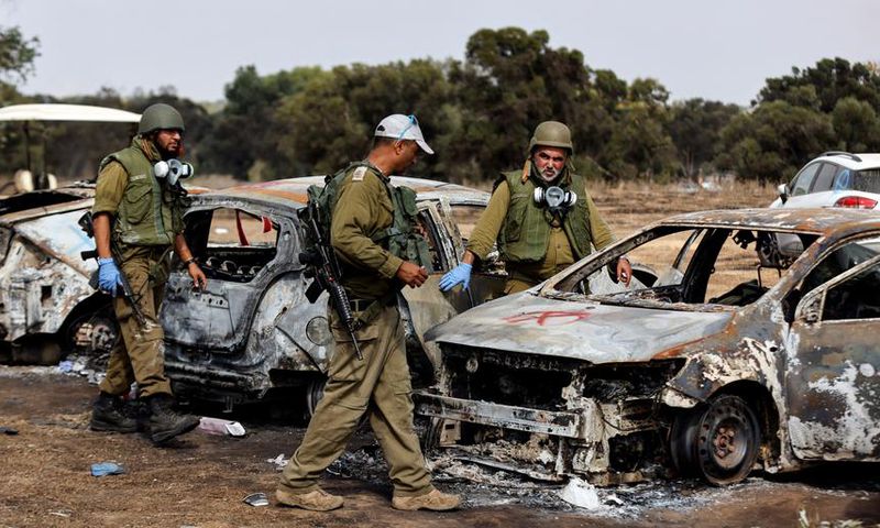 Israel soldiers inspect burnt cars at the site of the Hamas terrorist attacks on the Nova music festival in southern Israel.Amir Cohen/Reuters