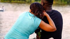 A lady and a man sitting by the river