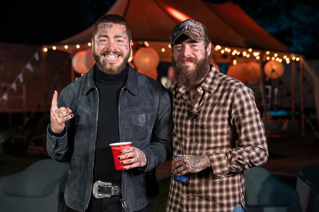 Post Malone posing next to his wax statue