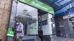 A customer wearing a protective face mask exits a Safaricom Plc store in central Nairobi, Kenya, on Tuesday, May 11, 2021. (Photographer: Patrick Meinhardt/Bloomberg via Getty Images)