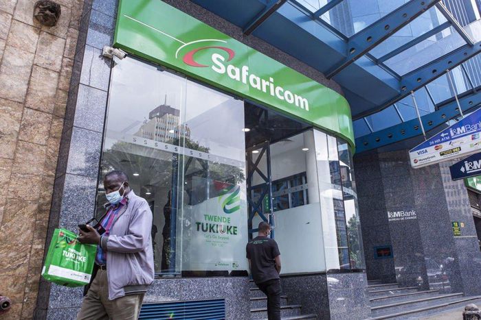 A customer wearing a protective face mask exits a Safaricom Plc store in central Nairobi, Kenya, on Tuesday, May 11, 2021. (Photographer: Patrick Meinhardt/Bloomberg via Getty Images)