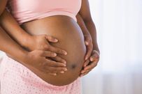 Husband and wife caressing bare pregnant stomach