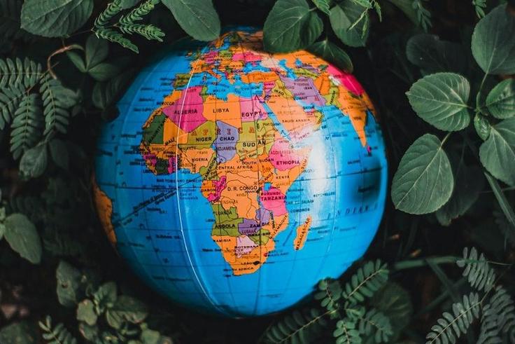 Globe in green leaves with map of Africa in view [Photo: Nothing Ahead]