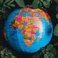 Globe in green leaves with map of Africa in view [Photo: Nothing Ahead]