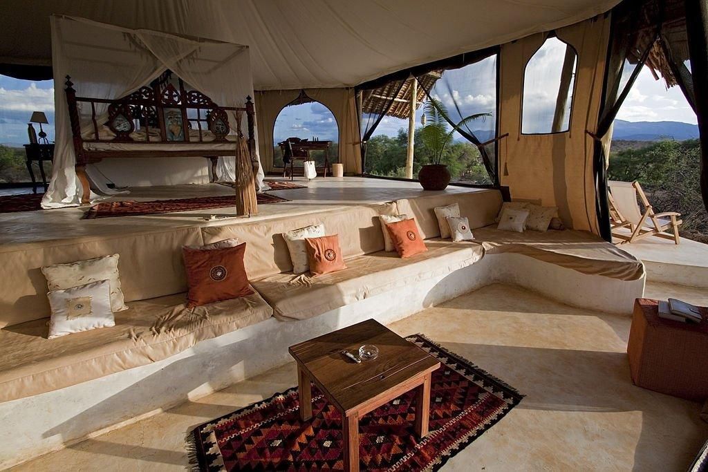 A luxurious safari camp bedroom in afternoon light