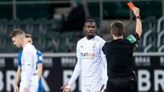 Moenchengladbach forward Marcus Thuram is shown a red card for spitting at an opponent on Saturday